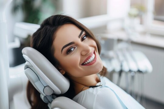 Happy Female Patient with Beautiful Teeth Smiling in Dental Chair at Dentist