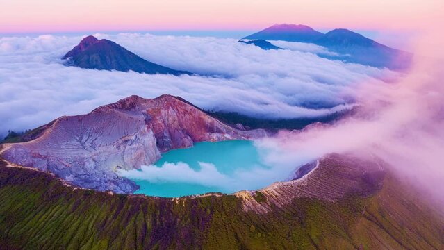 Aerial view Drone shot of fog at Kawah Ijen volcano with turquoise sulfur water lake and sunrise light.Amazing nature landscape view at East Java,Indonesia.Beautiful light Natural landscape background