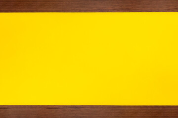 細長いビンテージ風の茶色い木材で上下を挟んだ黄色い背景