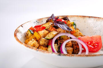 Vegetable Ratatouille with tomatoes, zucchini, pepper and seasonings in a plate on a white...