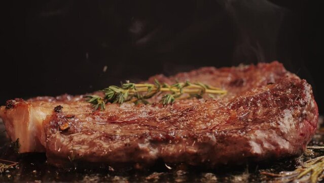 Fresh marbled beef with pepper, salt and rosemary close-up macro. Cooking juicy steak on grill with oil. Premium organic wagyu meat