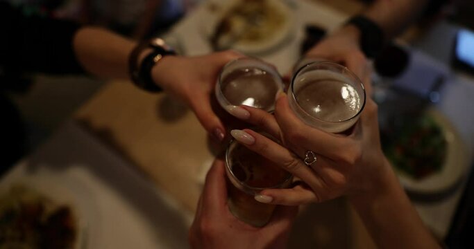 Group of friends drinking and toasting beer in restaurant or brewery