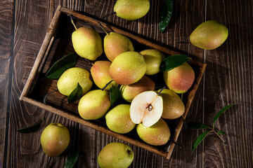 fresh ripe pears with half on wooden table.