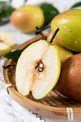 fresh ripe pears with half on wooden table.
