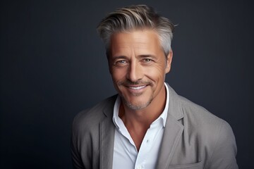 Portrait of a handsome mature man over grey background. Men's beauty, fashion.