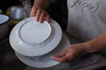 Incognita photograph of hands washing a dish in South America.