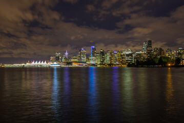 Beautifully illuminated cityscape of Vancouver, BC at night reflected in the ocean inlet