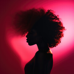Silhouette of a woman with an afro in pink backlight