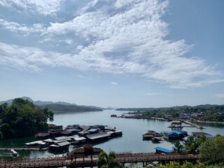 The bridge is embraced by verdant mountain ranges, surrounded by plants of diverse species, and covered by a thin layer of fog. The dazzling bridge that reflects the charm of local people's way of lif