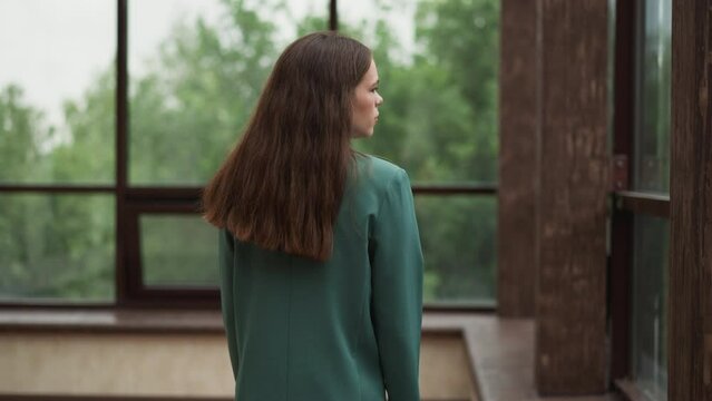 Lady ambles beside sweeping glass panels. Series of regulatory setbacks dampens optimism in woman worker casting doubt on viability of upcoming projects