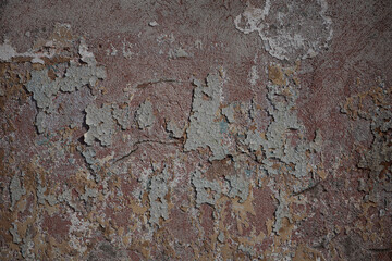 Cracked and textured red and blue background on an old concrete wall. Peeling paint on the wall. concrete wall with old cracked flaking paint.
