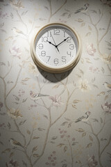 A round clock on the wall indicates the exact time. The decor in the room, copy space.
