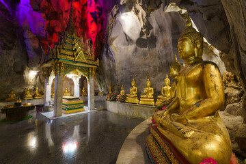 
The golden Buddha statues are placed inside a cave at Tham Khao Yoi Temple in Phetchaburi Province. It's a beautiful tourist attraction in Thailand.