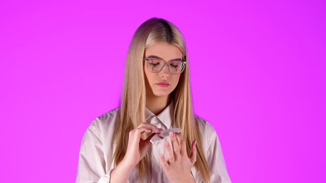 Gorgeous blonde woman filing her fingernails, wellness treatment, studio shot