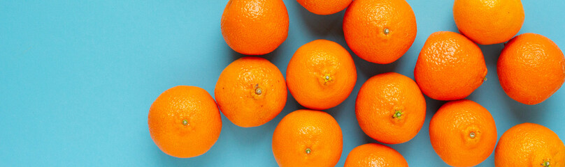 Oranges top view banner on blue background. Vibrant photo of citrus fruits flat lay. Vitamin C baner