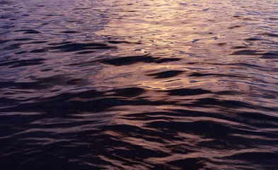 Papier Peint photo Rouge, noir, blanc Sunlight reflecting on ocean waves on sunset time background