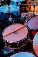 Fototapeta na wymiar Pair of drumsticks lies on a drum kit on stage