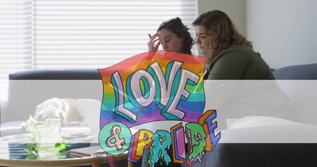 Image of love and pride over lesbian couple doing paperwork