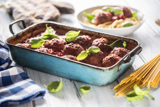 Delisious italian meal meat beef balls with pasta spaghetti and basil in vintage roaster pan