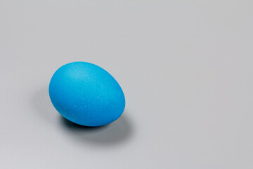 Blue Easter egg on the grey background.
