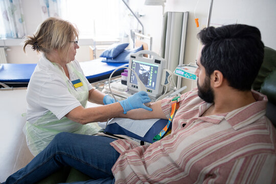 Female doctor analyzing and doing doppler test of male patient in hospital