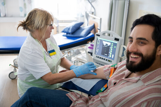 Female doctor analyzing doppler test of smiling male patient in hospital