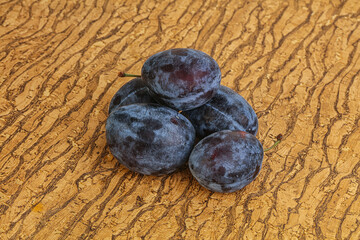 Ripe plum heap over background