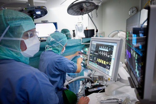 Female surgeons examining medical report on computer at hospital