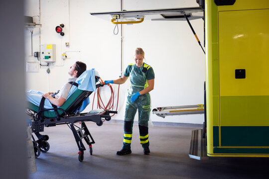 Female paramedic with male patient on gurney in hospital