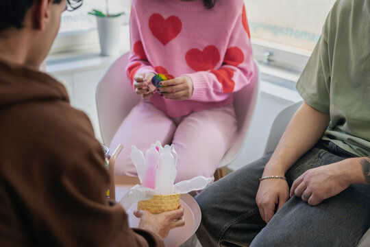 Midsection of friends discussing over condoms while sitting in clinic