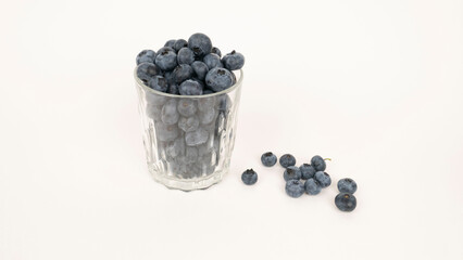 Ripe blueberries in crystal glass closeup on a white background