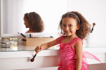 Child, portrait and mirror with makeup for costume, ballet or performance with cosmetics or brush. Girl, smile and reflection of a happy kid in with a princess dress or outfit in the home or house © Mariusz/peopleimages.com