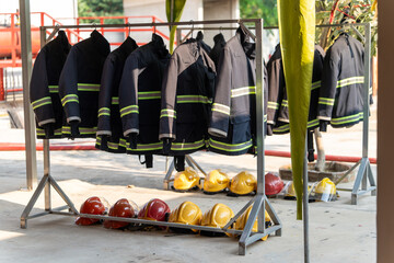 A fire suit was hung on a railing. And there were several yellow and red firefighter helmets lying on the floor.