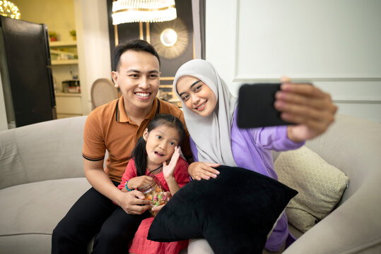 Indonesian family doing selfie for picture or memory together at home.