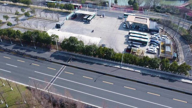 Aerial view of electric bus station near highway, technology advancement, clean energy urban area