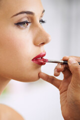 Face, woman and lipstick brush on lips for beauty with hands, application of cosmetics product and...