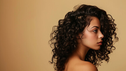 Woman with dark curly hair isolated on beige background, close up view