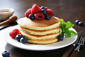 Pancakes with raspberries and blueberries with honey. Morning,pancakes for breakfast
