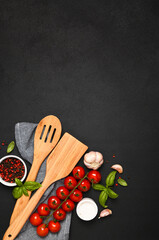 Spatula and kitchen towel and tomatoes on a black background. Food background - 752041672