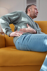 Man with stomach pain at home.