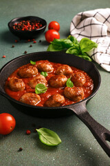 .Meatballs with tomato sauce and basil in a frying pan
