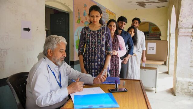 Election officer verifying identity card for Indian voter before voting - Indian democracy  voter ID verification  general elections  Indian citizens. The government employee checking the voter IDs...