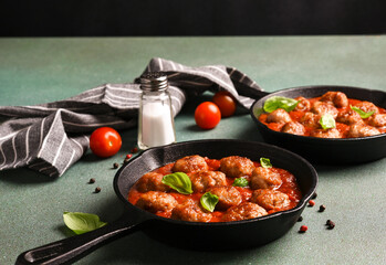 .Meatballs with tomato sauce and basil in a frying pan