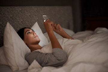 Woman, scrolling and phone for social media, bed and relaxation under blankets in pajamas to sleep. Female person, browse and tech for peace, night and online for conversation, chat and memes - obrazy, fototapety, plakaty