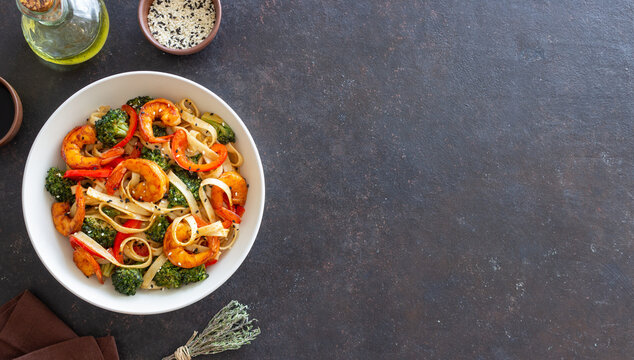 Udon noodles with shrimp, broccoli and peppers. Asian cuisine. - Powered by Adobe