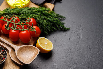 Cooking scene: Cherry tomatoes, herbs and spices on table