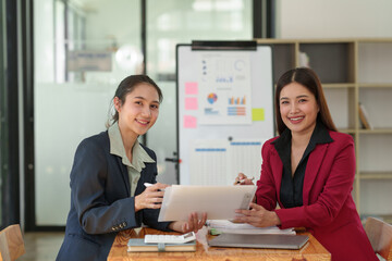 Business team Negotiation, Analysis, Discussion, Asian woman economist and marketer pointing to a financial data sheet to plan investments to prevent risks and losses for the company.