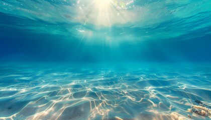 Fototapeta na wymiar Seabed sand with blue tropical ocean above and sunny blue sky, empty underwater background with the sun shining brightly, creating ripples in the calm sea water