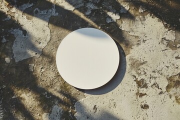 White round coaster mockup on a textured concrete background with shadow play