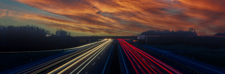 panorama car driving on highway at sunset in the sky